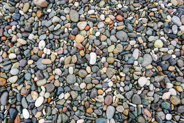 A lot of coloured pebbles on a shore for a background of natural material