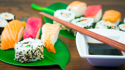 Maki and nigiri sushi set on green leaf  background. Close up