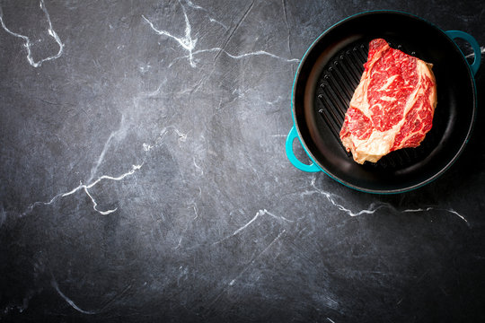 Raw Fresh Marbled Meat Beef Steak on the grill pan. Top View Copy space for Text