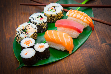 Maki and nigiri sushi set on green leaf  background. Close up