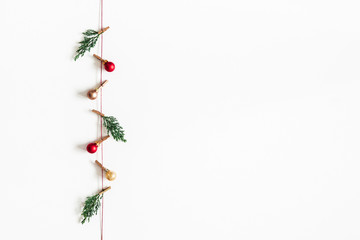 Christmas composition. Garland made of red and golden balls, fir tree branches on white background. Christmas, winter, new year concept. Flat lay, top view, copy space