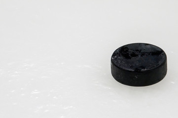 black hockey puck on ice rink. Winter sport.