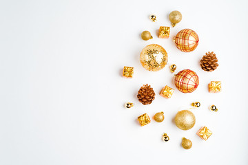 christmas decorations in gold colors on white background with empty copy space for text. holiday and celebration concept for postcard or invitation. top view, flat lay