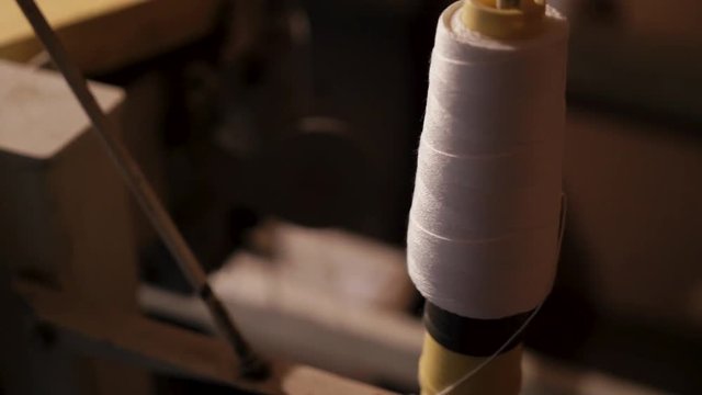 Close-up of big bobbin with white thread for packing grain in bags