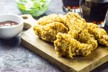 Fried chicken wings on wooden cutting board.