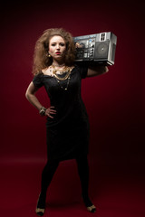 Girl with boom box, 1980's style. red backdrop.