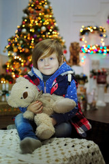 Ребенок ждет чуда в Новый год. С новым годом! Счастливого Рождества! Новогодняя елка с рождественскими игрушками. Мальчик с игрушками.

