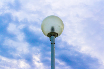 Street lamp against the background of the river and sky