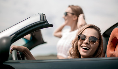close up.two girlfriends traveling in a convertible car