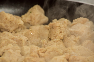 Textured vegetable protein is fried with steam in a pan, close