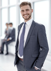 smiling businessman standing in modern office