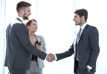 handshake of business partners in a bright office