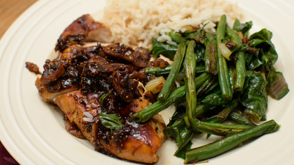 Closeup of roasted chicken with rice and roasted green beans with swiss chard and kale on plate ready to eat healthy eating photography