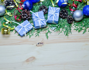 Christmas background snow gifts Christmas balls and streamers and tree branches and cones on wooden background 
