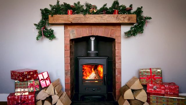 Merry Christmas beautiful video with fireplace, Xmas tree garland, wood logs and presents, pleasant atmosphere and luminous fire. Best use for Xmas gifts and titles with a greeting inscription.