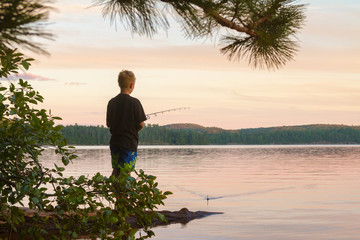 Boy fishing at sunset