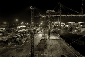 Odessa, Ukraine, Circus 2012: Sea commercial cargo port at night. Unloading, loading sea containers on a cargo ship at night. Container site with large sea freight containers with industrial goods