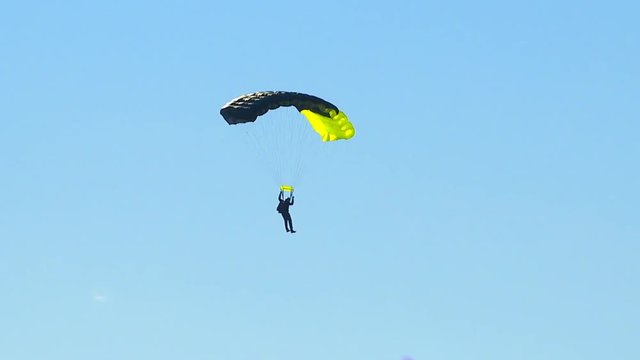 Athletes parachute from an airplane flying high in the sky.