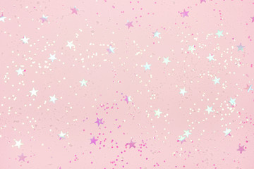 Beautiful pastel pink Christmas background with star shaped confetti. Top view. Copy space for your design.