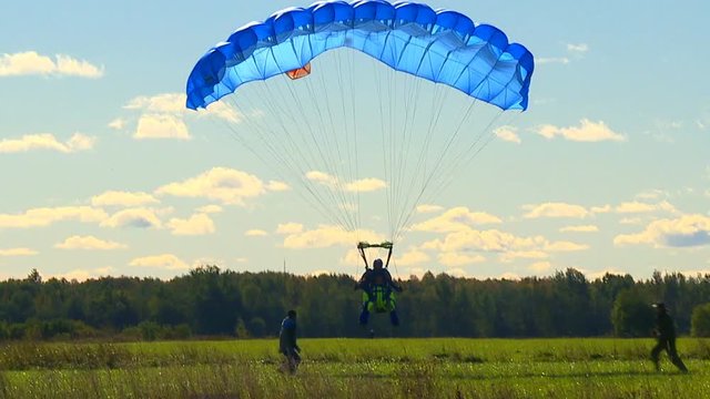 Athletes parachute from an airplane flying high in the sky.