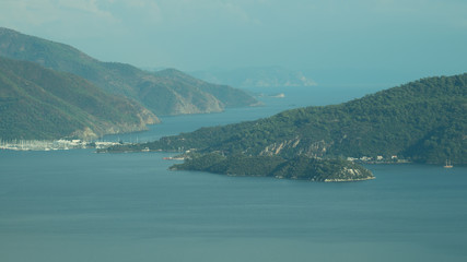 Fototapeta premium Overgrown mountains on the islands. Seascape background. water surface in a bay