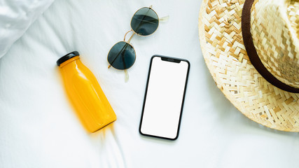 Top view blank screen of smartphone on room and hat, glasses, During leisure time. The concept of using the phone is essential in everyday life.