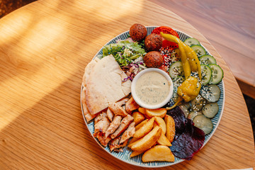 Dish of palestinian or israeli food - falafel, pita and vegetables