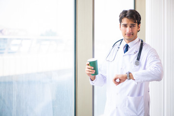 Young handsome doctor standing at the window 