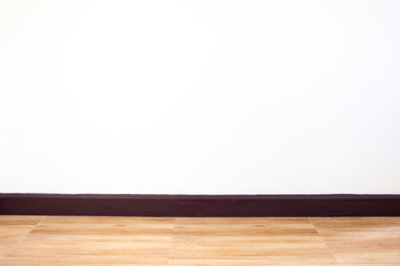 Empty white concrete wall in the room with wooden floor.  Background and texture.