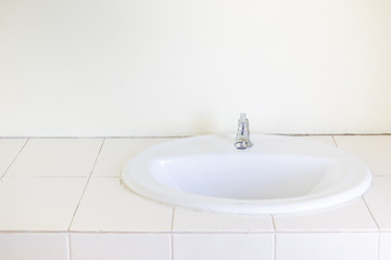 White ceramic washbasin installed in the kitchen room.