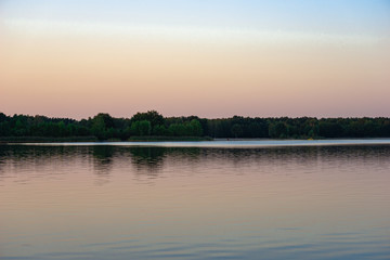 Blue lake with cloudy sky, nature series, a lake landscape with reflection from some trees.