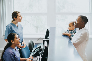 Nurses conversing with a patient at the reception - Powered by Adobe