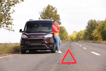 Fototapeta na wymiar Emergency stop sign and driver near broken car on road. Auto insurance