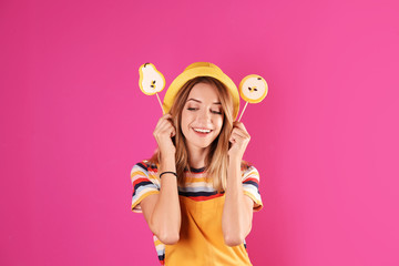 Young pretty woman with candies on colorful background