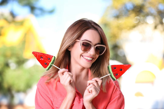 Young happy woman with sweet candies outdoors