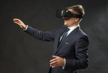 Man in black suit uses a virtual reality glasses.  VR 360. Virtual game