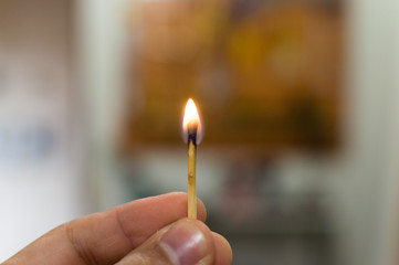 Matchstick holding fire in hand