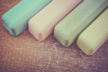 Retro colored chalk sticks on old wood board as copy space background
