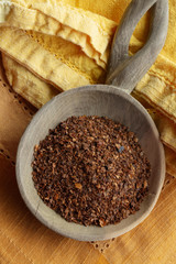 Aleppo pepper on round wood spoon.