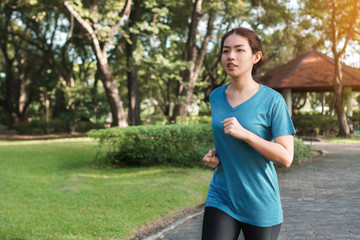 Exercise and healthy concept, Young asian runner woman running in the park in sportswear morning time, selective focus