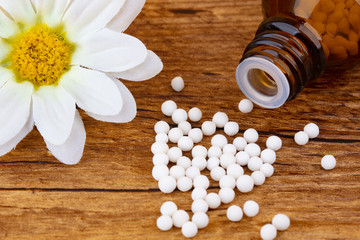 Obraz na płótnie Canvas Homeopathy medicine with blossom of a flower