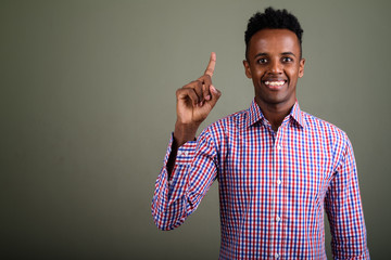 Young handsome African businessman against colored background