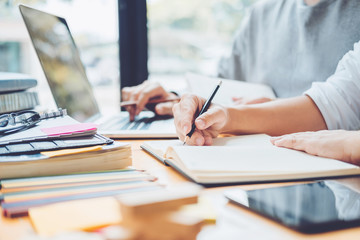 High school or college students studying and reading together in library