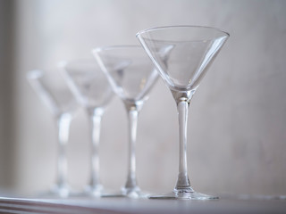 Empty wine glasses on a window sill, sea and sky in the blurred background