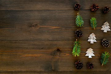 Winter ornament, New Year pattern. Pine sprigs, cones, spruce figure, fir oil on dark wooden background top view space for text