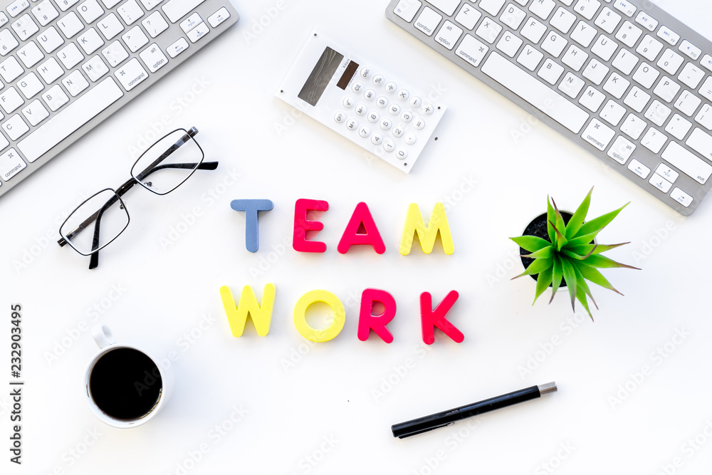 Poster teamwork in office. text teamwork lined with colored letters on white office desk with computer keyb