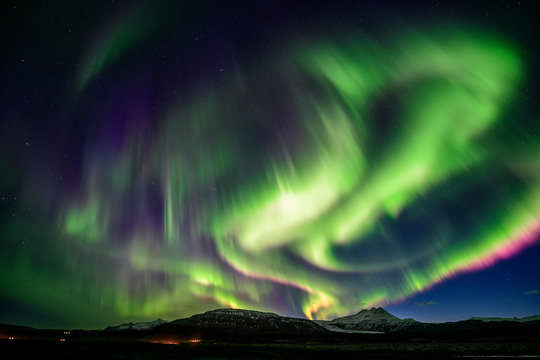 Strong Aurora over mountain at night in Iceland