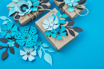 Gift box wrapped in craft paper blue background.