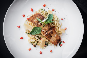 fresh fish fillet on mixed vegetable and parmesan spaghetti pasta