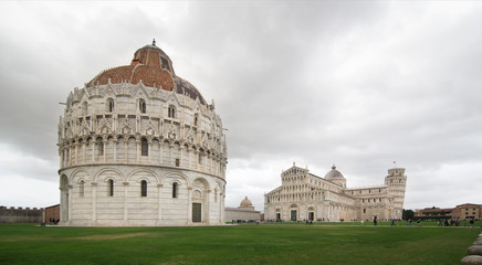 PISA, ITALY - OCTOBER 29, 2018: The Baptistery in the foreground, the Duomo in the center, and the leaning tower in the background on the right
